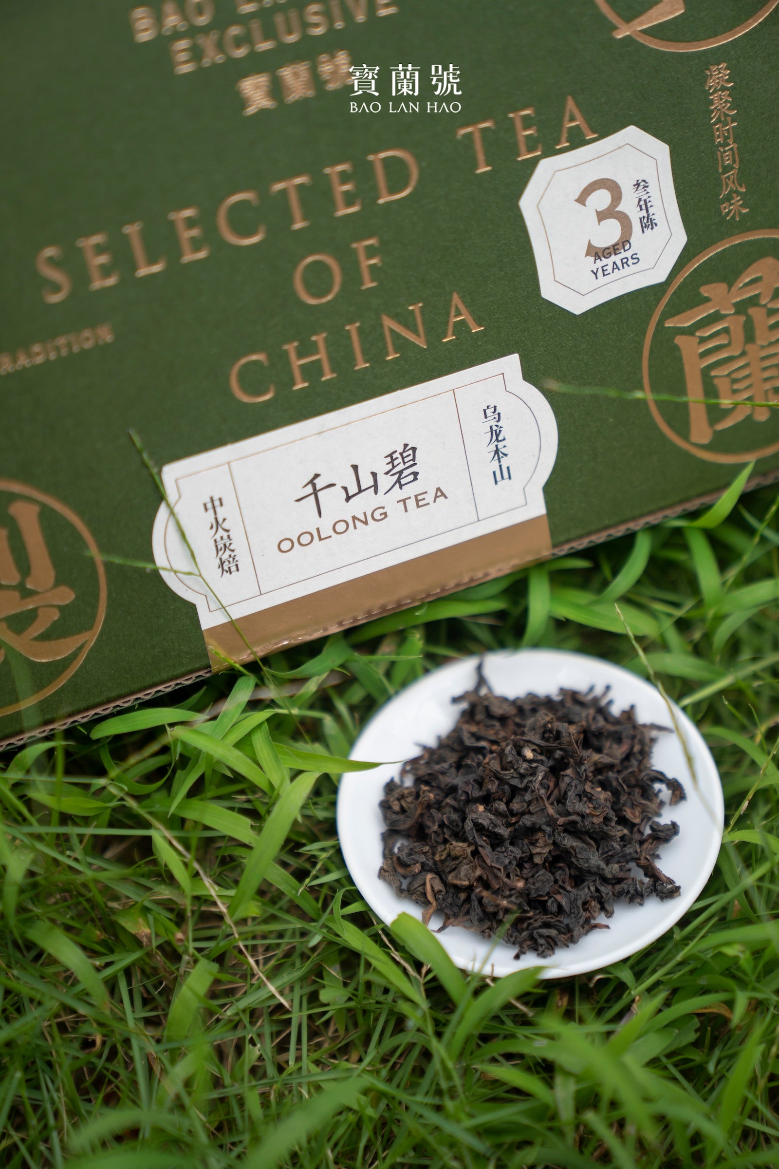 Oolong tea leaves in a white bowl beside a green oolong tea box